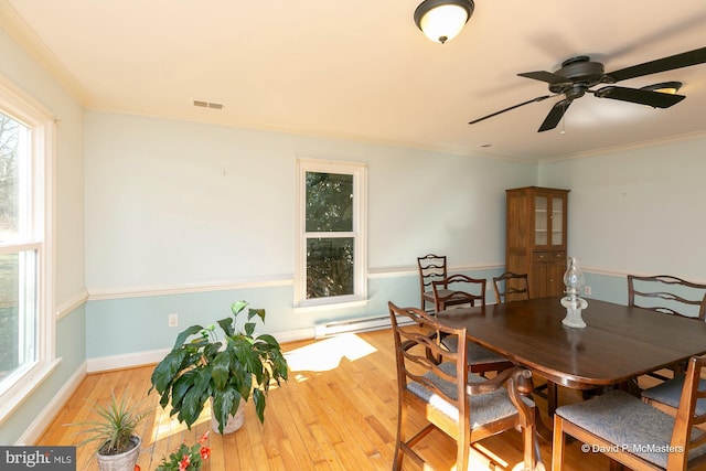 dining area featuring ornamental molding, light wood-type flooring, and baseboard heating