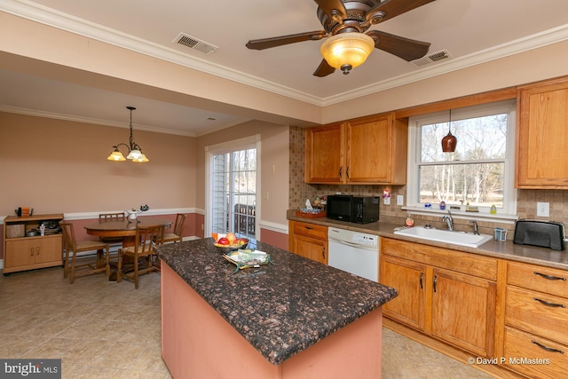 kitchen featuring dishwasher, sink, a kitchen island, and a wealth of natural light