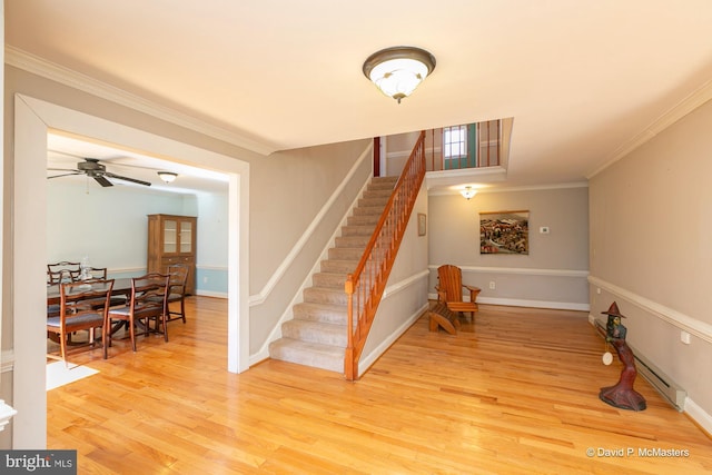 staircase featuring ornamental molding, wood-type flooring, and ceiling fan