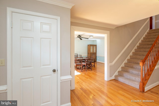 hall with wood-type flooring and ornamental molding