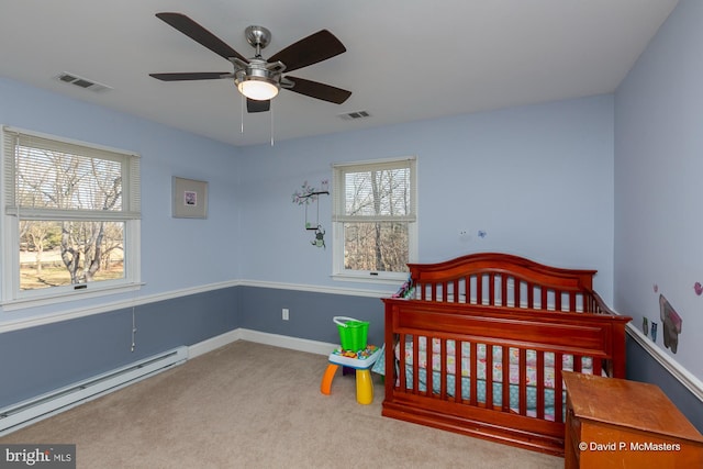 bedroom with a baseboard heating unit and light carpet