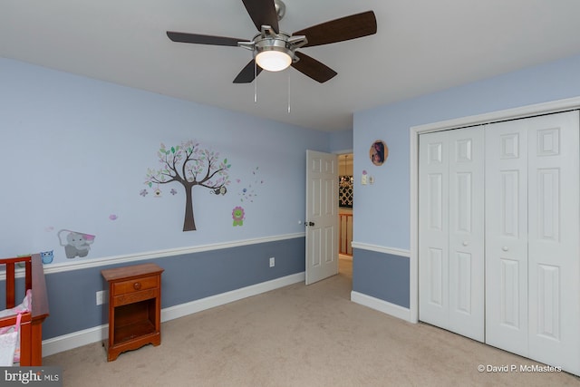 unfurnished bedroom featuring light carpet, ceiling fan, and a closet