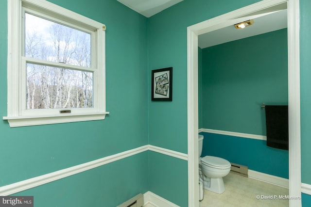 bathroom featuring baseboard heating and toilet