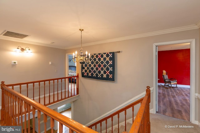 hall featuring crown molding, carpet, and a chandelier