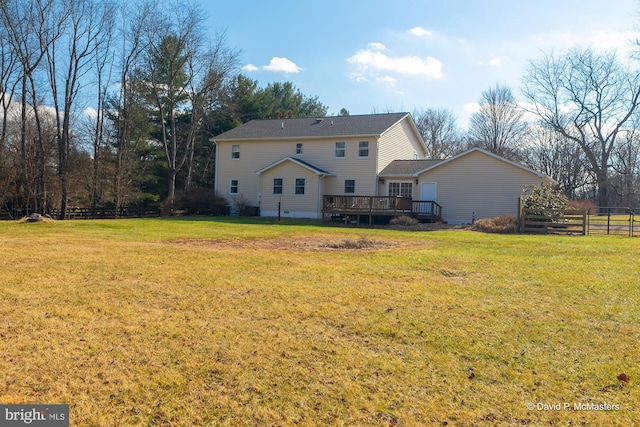 back of property with a yard and a deck