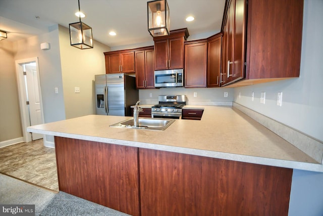 kitchen featuring appliances with stainless steel finishes, sink, pendant lighting, and kitchen peninsula