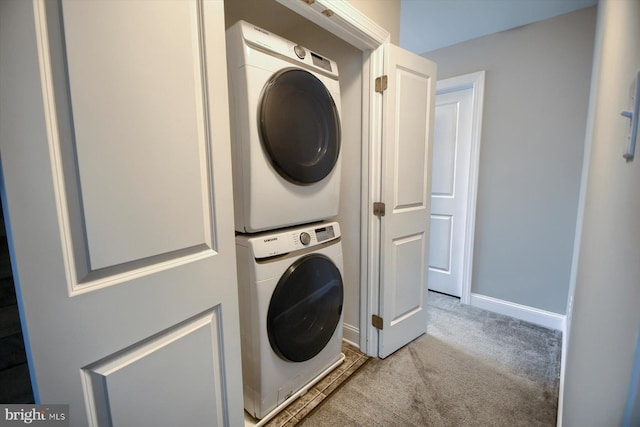 clothes washing area featuring light colored carpet and stacked washer / dryer