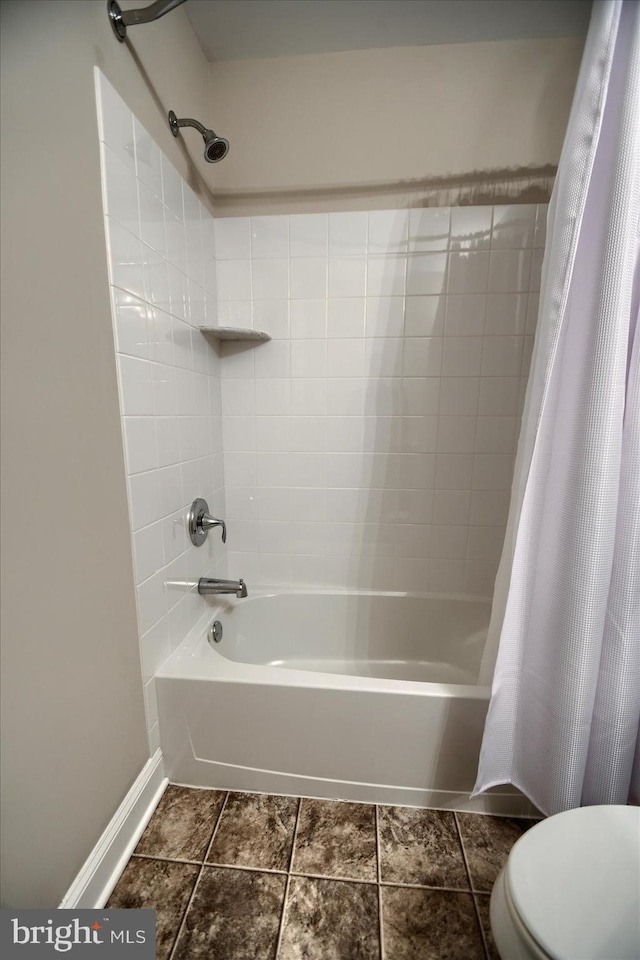 bathroom featuring shower / bath combination with curtain and toilet