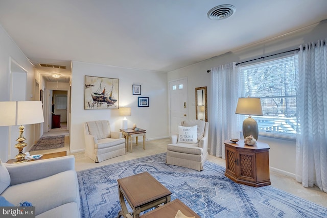 carpeted living area with attic access, visible vents, and baseboards