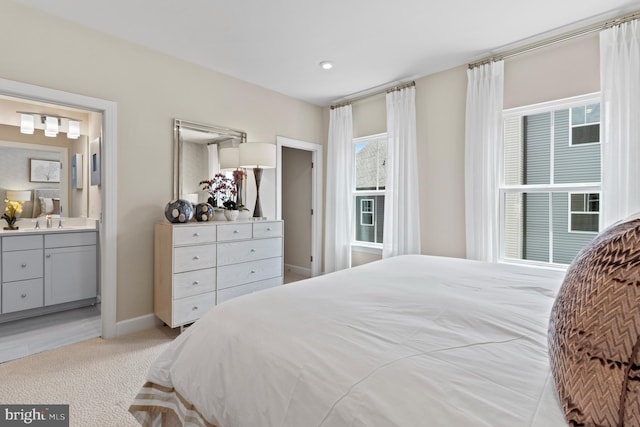 carpeted bedroom featuring sink and connected bathroom