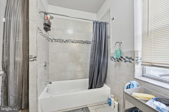 bathroom with tile walls and shower / tub combo with curtain