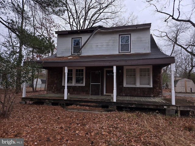 farmhouse featuring a storage unit and covered porch