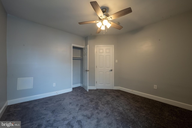 unfurnished bedroom featuring ceiling fan, dark carpet, and a closet