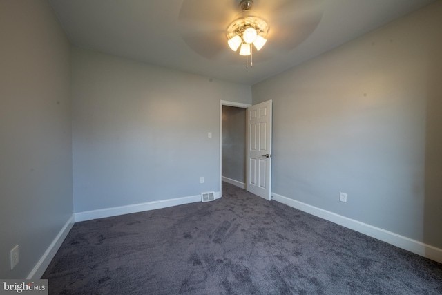 empty room featuring dark carpet and ceiling fan