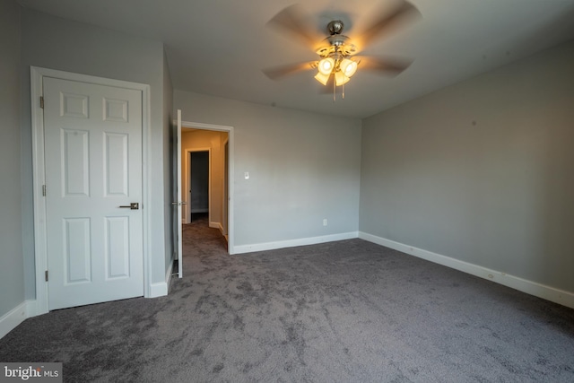 unfurnished bedroom featuring ceiling fan and dark carpet