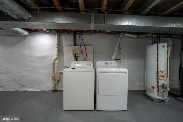 clothes washing area with gas water heater and separate washer and dryer