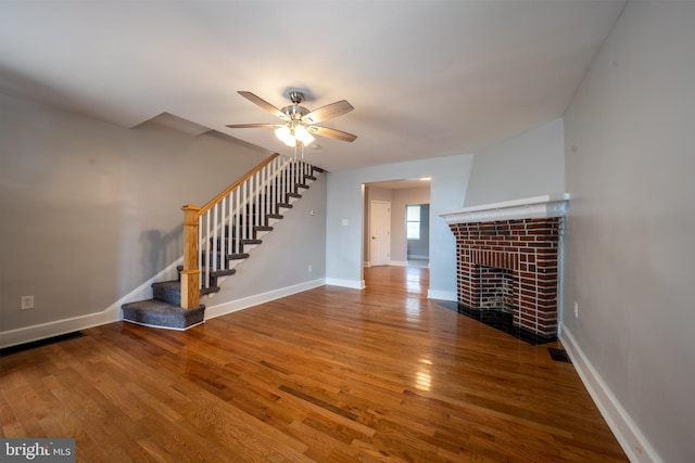 unfurnished living room featuring hardwood / wood-style flooring, a fireplace, and ceiling fan