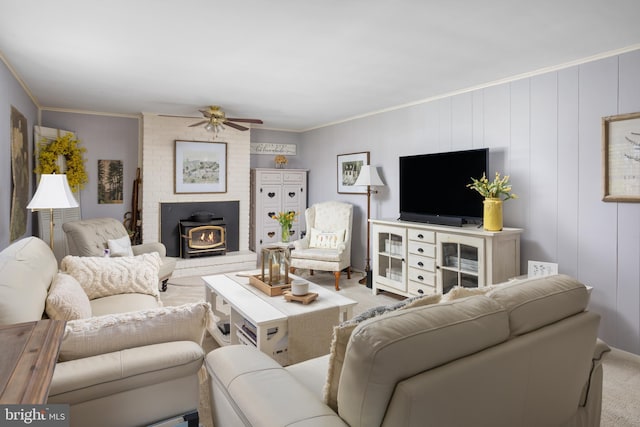 carpeted living room with a wood stove, ornamental molding, and a ceiling fan