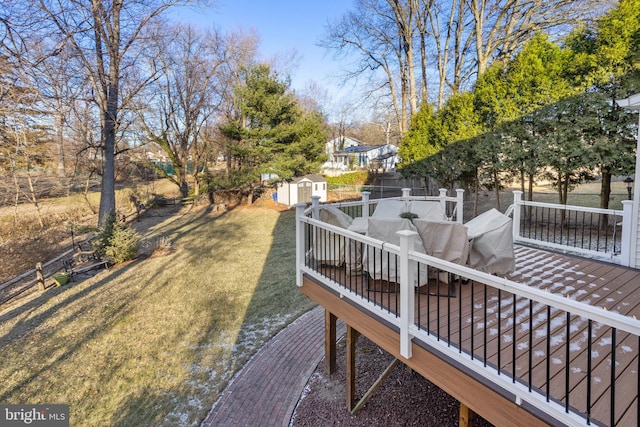 view of yard featuring an outbuilding, outdoor dining area, a fenced backyard, and a storage unit