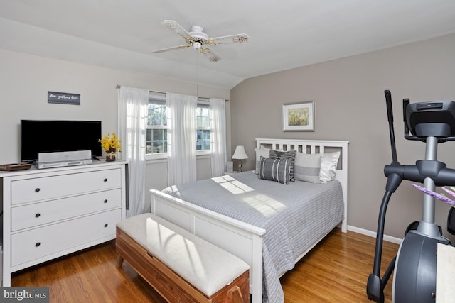 bedroom with ceiling fan, vaulted ceiling, baseboards, and wood finished floors