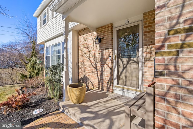 doorway to property with brick siding