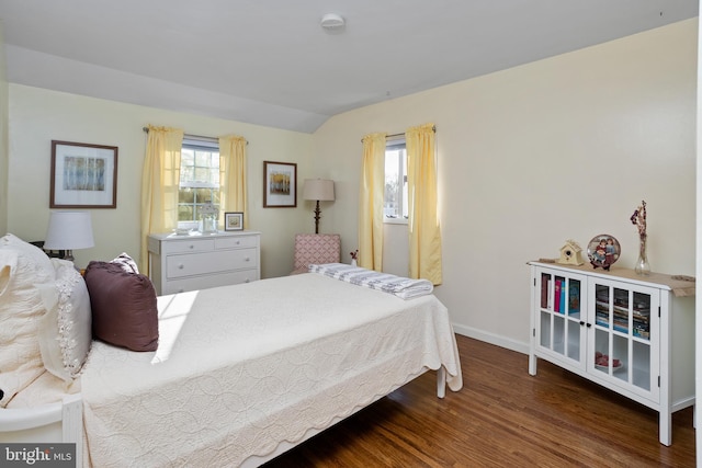 bedroom with vaulted ceiling, baseboards, and wood finished floors