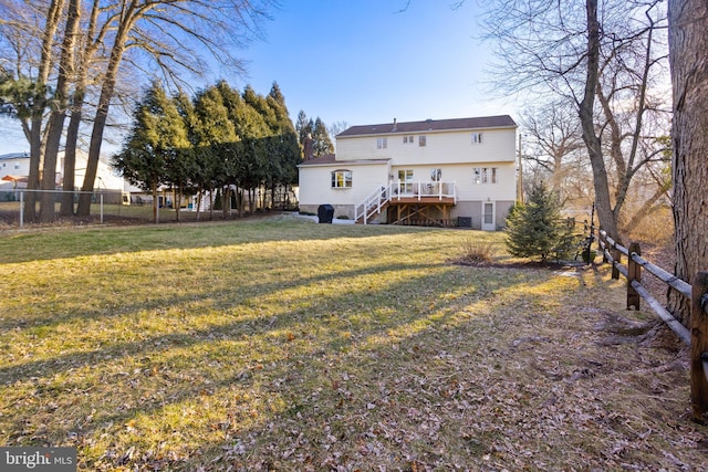 rear view of house featuring a lawn, stairway, a wooden deck, and fence