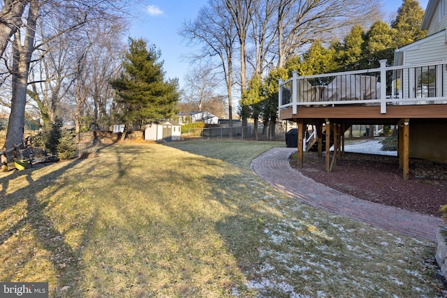 view of yard with an outbuilding, a storage unit, stairway, fence, and a wooden deck