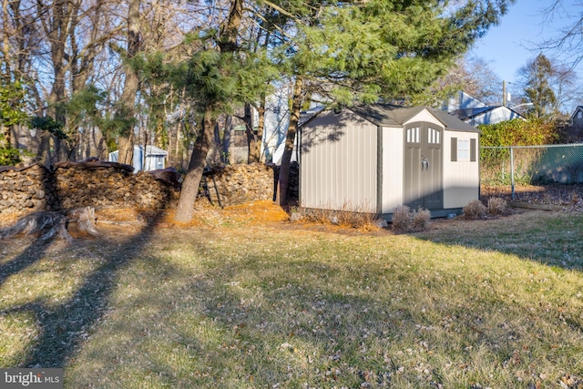 view of yard with an outbuilding, fence, and a storage unit