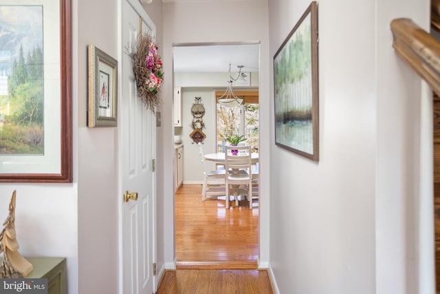 hallway featuring wood finished floors and baseboards