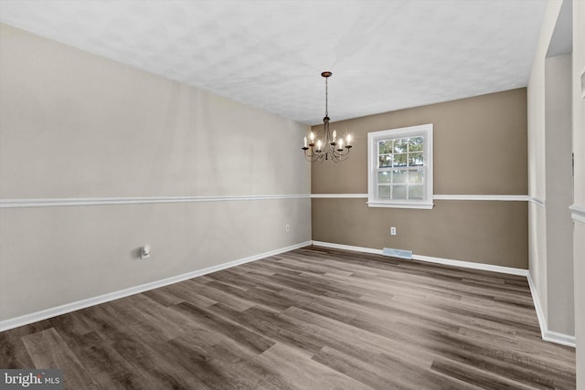 unfurnished dining area with wood-type flooring and a chandelier