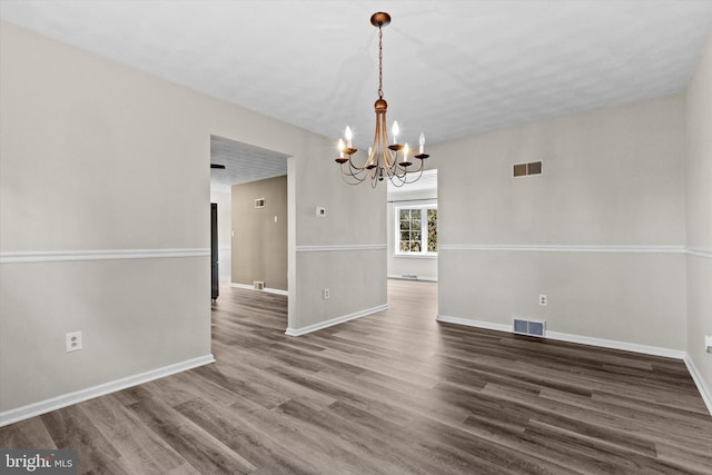 unfurnished dining area featuring dark hardwood / wood-style flooring and a chandelier