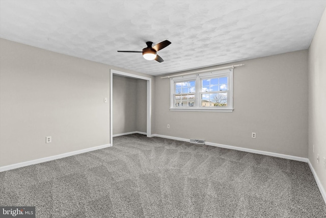 unfurnished bedroom with ceiling fan, carpet floors, a textured ceiling, and a closet