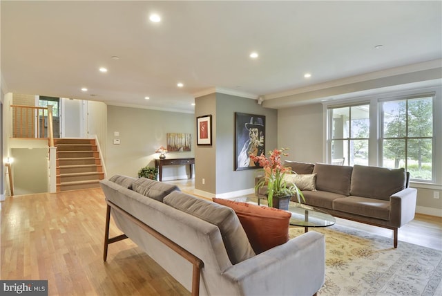 living room with ornamental molding and light hardwood / wood-style floors