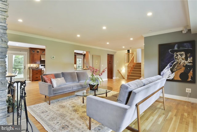 living room with ornamental molding and light hardwood / wood-style flooring