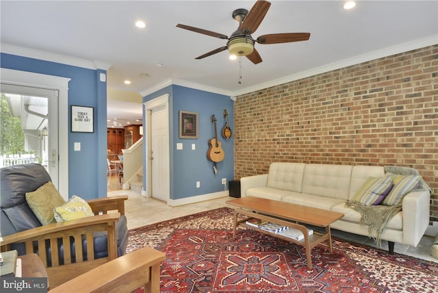 tiled living room featuring ceiling fan, ornamental molding, and brick wall