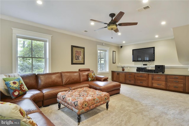 carpeted living room with crown molding, a wealth of natural light, and ceiling fan