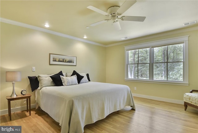 bedroom featuring crown molding, ceiling fan, and light wood-type flooring