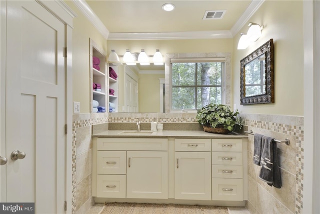 bathroom featuring crown molding, vanity, and tile walls