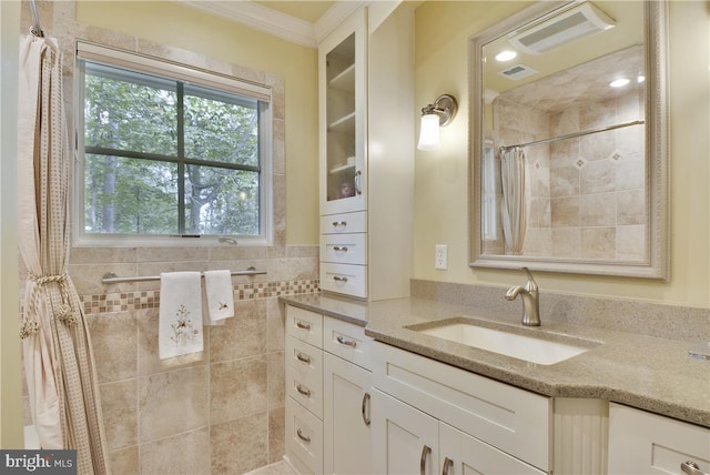 bathroom featuring crown molding, vanity, and walk in shower