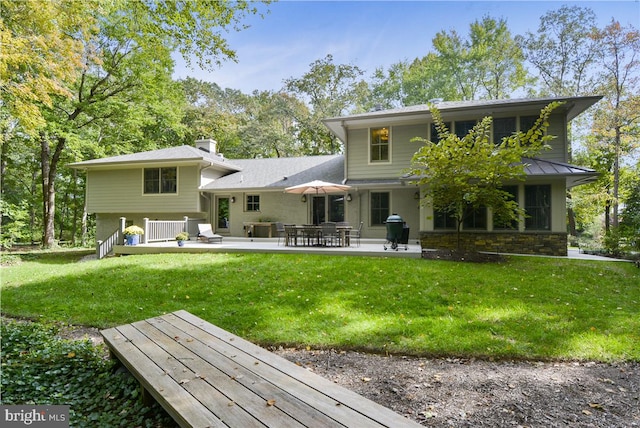 back of property featuring a patio and a lawn