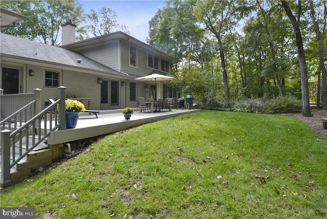 back of house with a yard and a deck