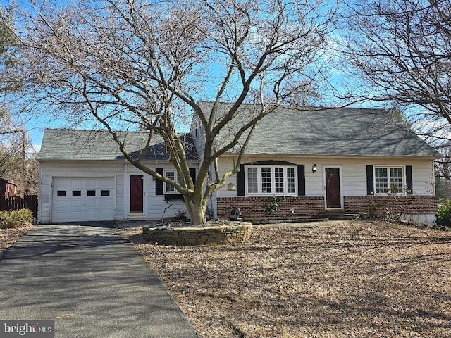 view of front of property with brick siding, roof with shingles, an attached garage, entry steps, and driveway