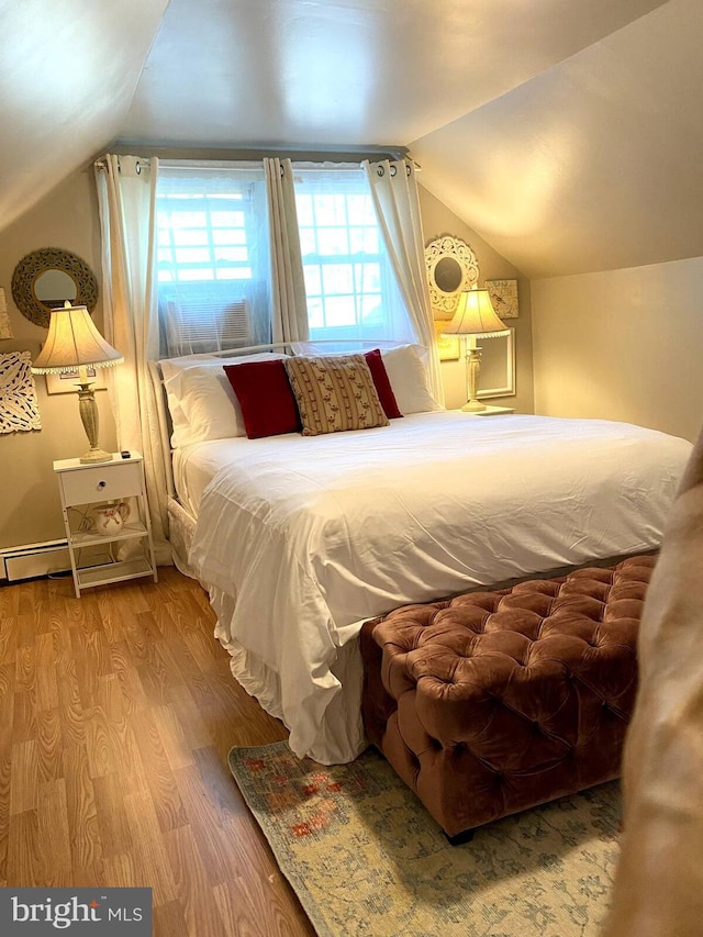 bedroom featuring lofted ceiling and wood finished floors