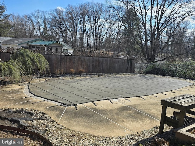 view of swimming pool featuring a patio area, fence, and a fenced in pool