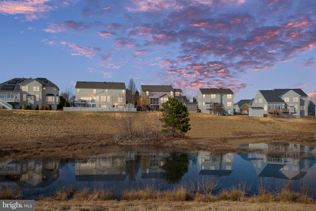 back house at dusk featuring a water view