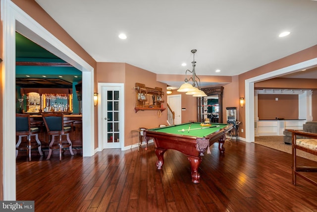 game room with dark hardwood / wood-style floors, pool table, and bar area