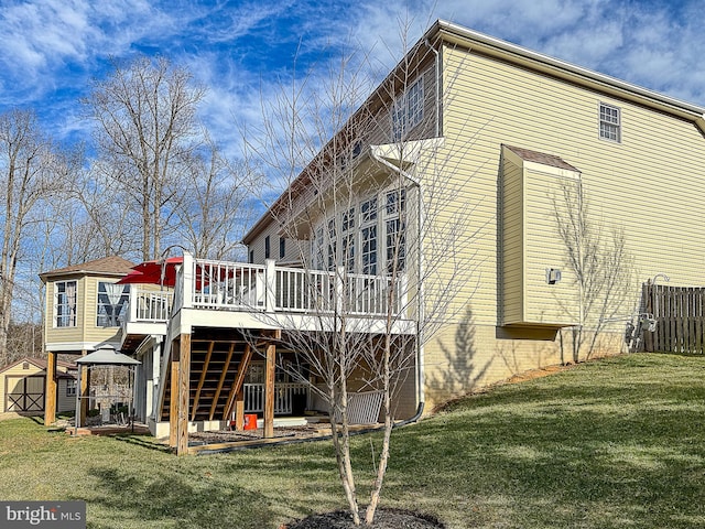 back of property with a wooden deck, a storage shed, a yard, and a gazebo