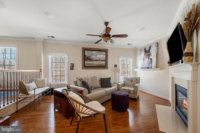 living room featuring crown molding, a high end fireplace, and hardwood / wood-style floors