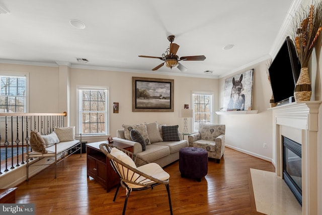 living room with hardwood / wood-style floors, a fireplace, and ornamental molding